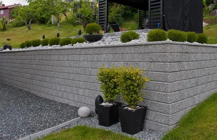 grå mur med to planter i front