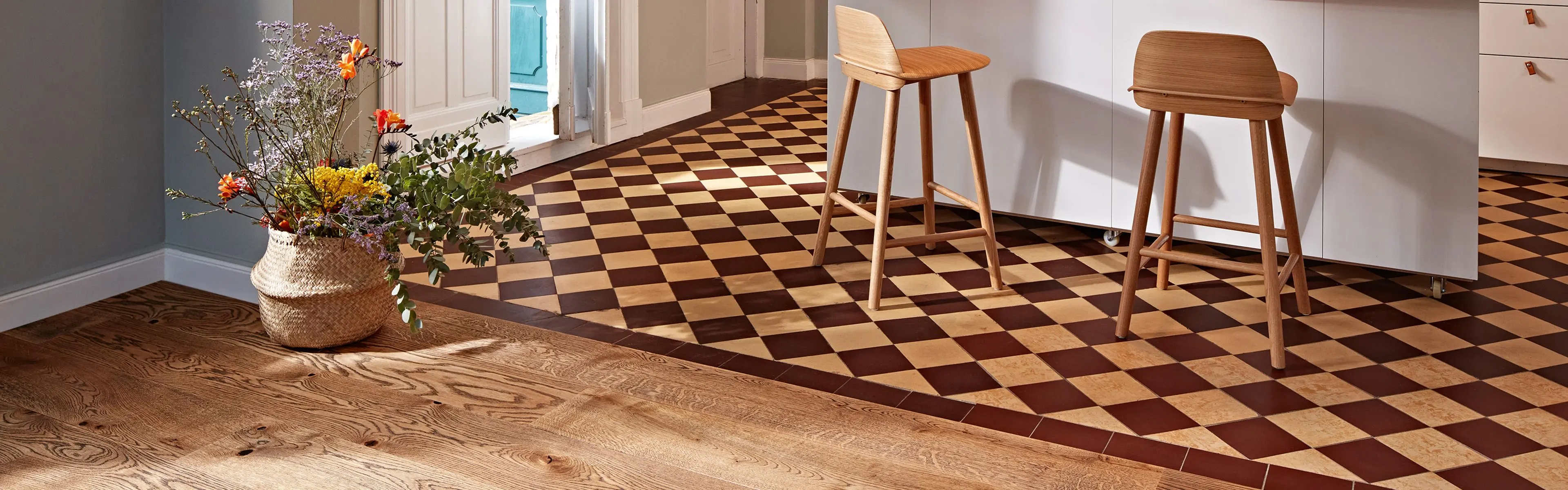 Stue og kjøkken med tregulv i enstavsparkett kombinert med gulv i hollandsk mønster.